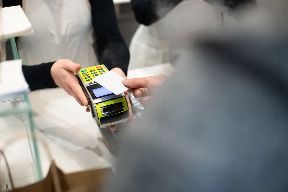 A card tapped on a store payment terminal, the kind of small everyday purchase people get a small loan to cover